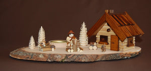 Räucherhaus mit Holzhacker auf ovaler Holzscheibe